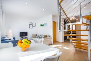 a living room with a table with a bowl of fruit on it at Feriapiso Apartments Palmer in Hospitalet de Llobregat