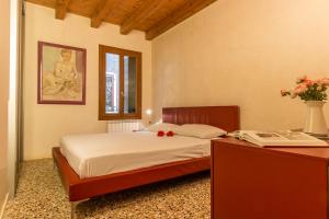 Un dormitorio con una cama y una mesa con flores. en Rialto Mercato a Family in Venice like at Home, en Venecia