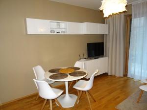 a dining room with a table and white chairs at Medvědín Apartmán 106 in Špindlerův Mlýn