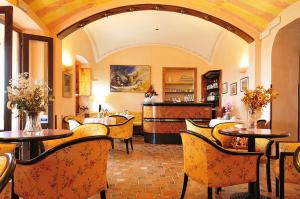 un restaurante con mesas y sillas en una habitación en Hotel Villa Campana, en Cala Liberotto