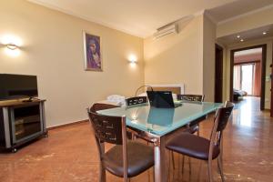 a room with a table with chairs and a television at Imperial Studios in Vasiliki