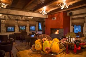 a table in a restaurant with a plate of fruit on it at Andromeda Hotel Limni Plastira in Koutsodímos