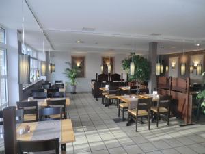 a dining room with tables and chairs in a restaurant at Hotel Pension Am Hafen in Norddeich