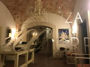 una sala da pranzo con lampadario a braccio e tavolo di Hotel & Residenza 100 Torri ad Ascoli Piceno