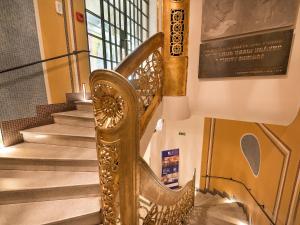 una escalera de caracol de oro en un edificio en EA Hotel Rokoko, en Praga