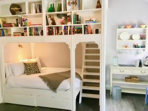 um beliche branco num quarto com uma estante de livros em Riverside House em Newport