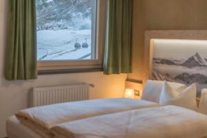 een slaapkamer met een bed en een raam met sneeuw bij Das Hochegg - Apartments in Obergurgl