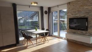 a dining room with a table and chairs and a tv at Alpenappartement Sonne in Umhausen