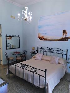una camera con letto, specchio e lampadario a braccio di B&B Art Suite Principe Umberto a Napoli