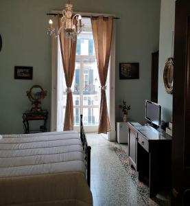 a bedroom with a bed and a desk and a window at B&B Art Suite Principe Umberto in Naples