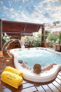 a woman laying in a pool in a hot tub at Hotel Spa Porto Cristo in Port de la Selva