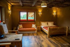 ein Schlafzimmer mit einem Bett, einem Sofa und einem Tisch in der Unterkunft Siedlisko Wigry in Rosochaty Róg