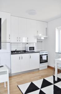uma cozinha com armários brancos e um tapete preto e branco em Apartments Lund em Lund