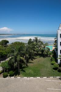 a view of the beach and palm trees from a building at Almasi Oceanfront Nyali in Mombasa