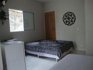 a bedroom with a bed and a window and a door at Kitnets & Flats in Ubatuba