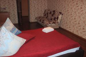 アルハンゲリスクにあるКвартира в центре Воскресенская 75к1のソファ、椅子、赤毛布が備わる客室です。