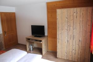 a bedroom with a wooden partition with a television on it at Haus Netzer Irma in Sankt Gallenkirch