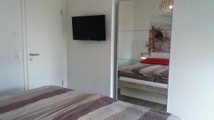 グロヴェにあるFerienwohnung Auszeitのベッドルーム1室(ベッド1台、壁にテレビ付)
