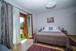 ein Schlafzimmer mit einem Bett und einem großen Fenster in der Unterkunft Sixteen Lakes Guest House 2 in Jezerce