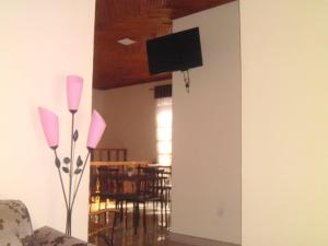 uma sala de estar com televisão na parede e objectos cor-de-rosa em Jasmine Garden Inn em Ella