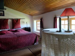 um quarto com uma cama e uma mesa com um candeeiro em Chambres d'hôtes de l'Abbaye em Montbrun-les-Bains