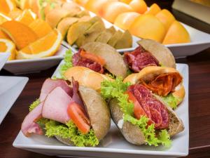 a plate of sandwiches on a table with other plates of food at EA Hotel Rokoko in Prague +32 photos