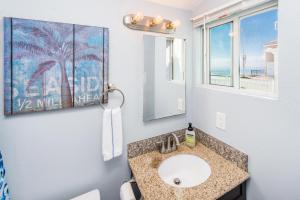 a bathroom with a sink and a mirror at Pacific Bungalow in Oceanside with Backyard & Tiny House in Oceanside +75 photos