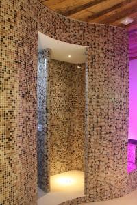 ein Bad mit einer gefliesten Wand und einem Spiegel in der Unterkunft Albergo Dei Pescatori in Piode