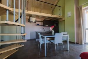a dining room with a table and white chairs at Eco-Residence in Casale Monferrato