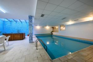 a large swimming pool in a building at Kap House Family Hotel in Bansko