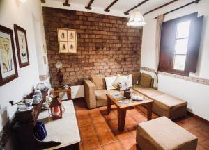 a living room with a couch and a brick wall at Finca Rural El Silbo - Casas Rurales in Hermigua