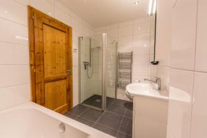 a bathroom with a tub and a sink and a shower at Chalet Asphodel in Plan Fey