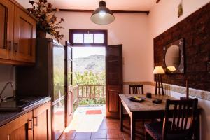 een keuken met een tafel en uitzicht op een berg bij Finca Rural El Silbo - Casas Rurales in Hermigua