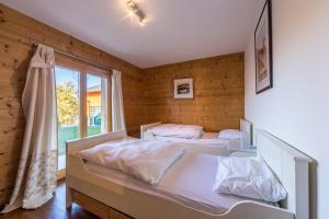 two beds in a room with a window at Chalet Asphodel in Plan Fey