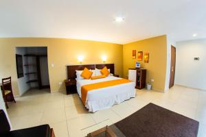 a hotel room with a large bed and yellow walls at Torre Hotel Ejecutivo in Santa Cruz de la Sierra +33 photos