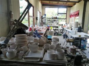 a room filled with white cups and bowls on a table at Frog Song Suite in The Crags