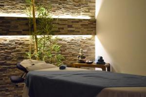 a bedroom with a bed and a stone wall at Vila Alba Resort in Carvoeiro