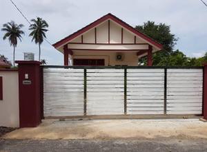 a house behind a fence with a gate at D’Noon Villa in Arau