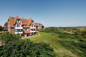 ein großes Haus an der Seite eines Hügels in der Unterkunft INSELHUS Apartments in Baltrum