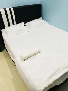 uma grande cama branca com lençóis e almofadas brancos em D’Noon Villa em Arau