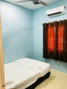 um quarto com uma cama e uma ventoinha de tecto em D’Noon Villa em Arau