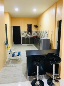 uma cozinha com dois bancos de bar num quarto em D’Noon Villa em Arau