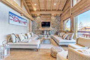 a living room with two couches and a tv at Chalet Annelya in Combloux