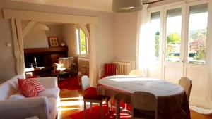 een woonkamer met een tafel en stoelen bij maison spacieuse renovée in Longeville-en-Barrois