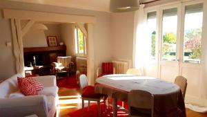 a living room with a table and chairs at maison spacieuse renovée in Longeville-en-Barrois