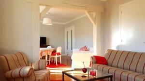 a living room with two couches and a table at maison spacieuse renovée in Longeville-en-Barrois