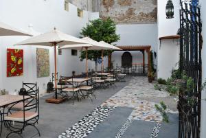 an outdoor patio with tables and chairs and umbrellas at Hotel Blanco Riad in Tétouan