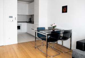 a dining room table with black chairs and a kitchen at Flexible SelfCheckIns 7 - Zagreb - Garage - Electric vehicle ccharger - Loggia - New - Luxury - Apartments Repinc 7 in Zagreb +24 photos