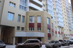 アルハンゲリスクにあるКвартира в центре Воскресенская 59の車が停まった建物