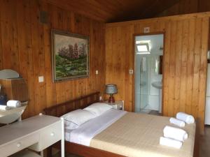 a bedroom with a bed and a bathroom with a sink at Casinhas do Ribeiro in Póvoa de Lanhoso